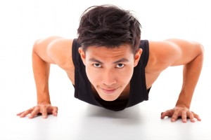 smiling young fitness man exercising push up
